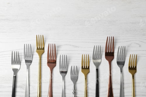 Preview: Flat lay composition with different forks on white wooden background, space for text