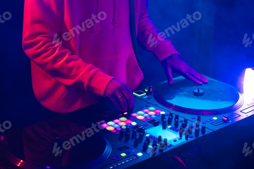 Preview: Hands of a DJ creating and regulating music on dj console mixer at club concert