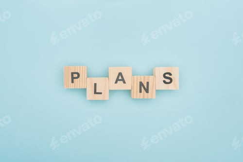 Preview: top view of plans lettering arranged of wooden cubes on blue background