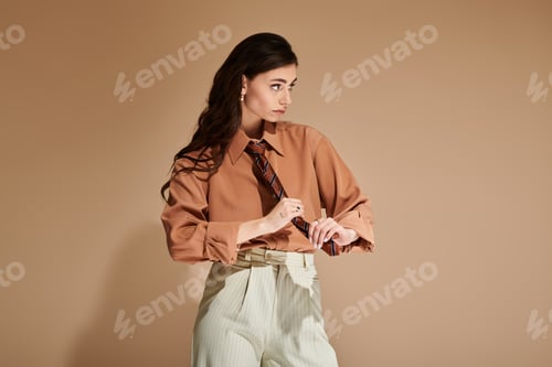 Preview: Fashionable young woman showcasing stylish attire in a contemporary studio setting
