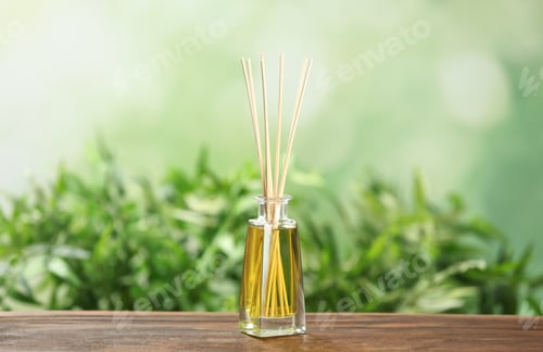 Preview: Reed air freshener on wooden table against blurred green background