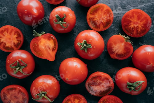 Preview: Top view of highly detailed red tomatoes on black background being wet