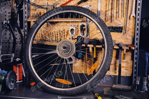 Preview: Bike wheel over service tool stand in a workshop.
