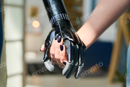 Preview: Young woman with black nail polish on fingernails holding by myoelectric hand