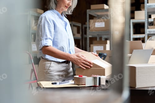 Preview: Female online store business owner packing ecommerce parcel shipping box.