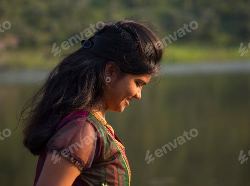 Preview: Young happy Indian girl playing with her pink scarf at outdoor.