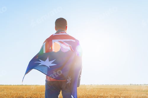 Preview: Man with a flag of Australia standing in field