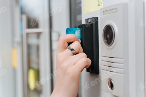 Preview: Woman opening door using card entry access system, close-up. Side view of woman's hand scanning