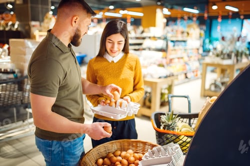 Preview: Family couple choosing eggs in grocery store