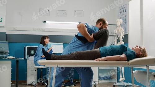 Preview: Orthopedic specialist and elder woman stretching arms and legs muscles