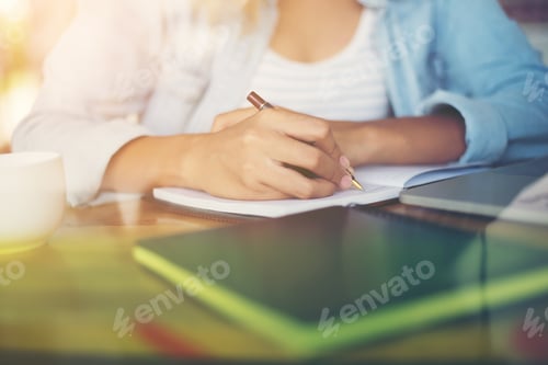 Preview: Close-up of young beautiful woman hands writing and work with laptop computer.