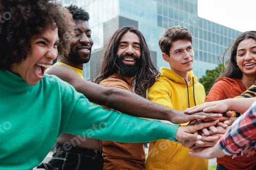 Preview: Young diverse group of people stacking hands together outdoor - Diversity team concept