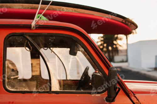 Preview: A stack of surfboards on a retro car roof with sun shining. Summer and surf background wallpaper.