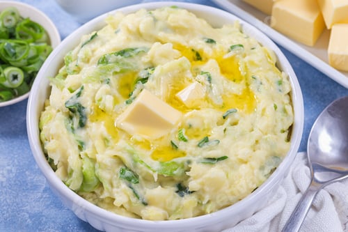 Preview: Traditional Irish dish Colcannon or mashed potato with green cabbage and butter, horizontal closeup