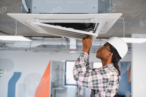 Preview: Technician repairing air conditioning ventilation system in office building