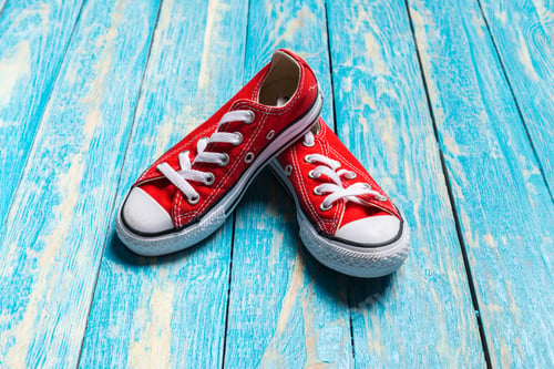 Preview: red sneakers on wooden background.