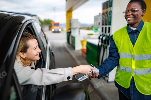 Preview: Woman paying for gas with credit card at service gas station