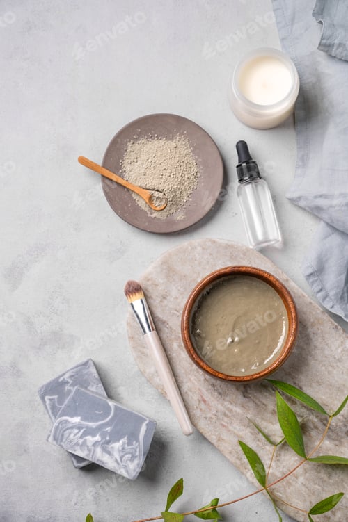 Vista previa: Organic cosmetic with blue clay on a marble board with brush, candle, soap and eucalyptus branch