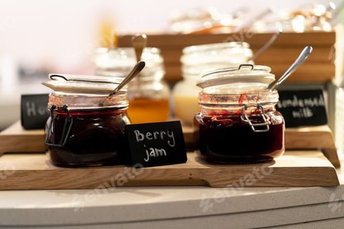 Preview: close-up breakfast buffet line serving a variety of jams in a hotel with hospitality signs