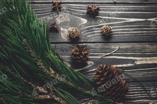 Preview: Green tree fir branches and pine cones anise top view on rustic wooden background