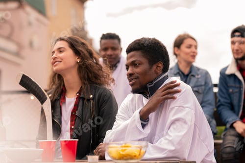 Preview: Young intercultural hockey fans watching match broadcast