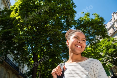Preview: Close up African american girl with bag smiling in city