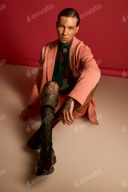 Preview: Stylish man poses against a vibrant pink backdrop, showcasing modern fashion flair