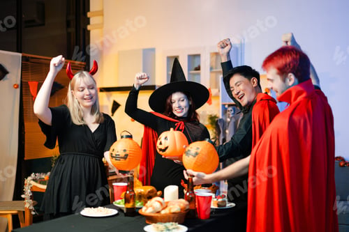 Preview: Group of friends in fun Halloween costumes laugh and play with spooky props, lanterns, and
