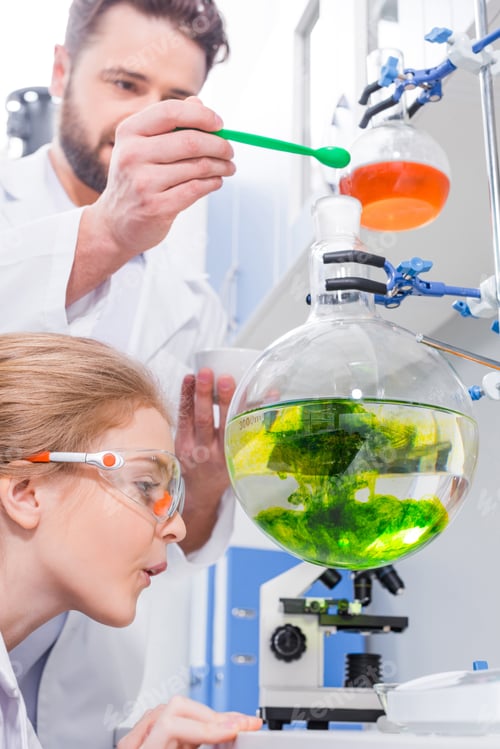 Preview: Teacher and student in white coats making experiment in laboratory