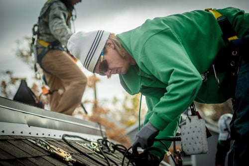 Construction crew installing solar panels on a house Construction crew installing solar panels on a house
