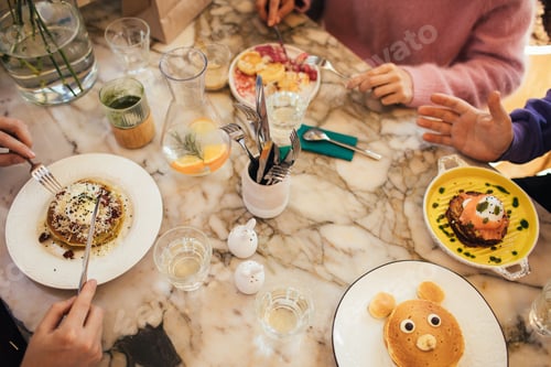 Preview: Group of millennial friends having breakfast together in a coffeeshop.