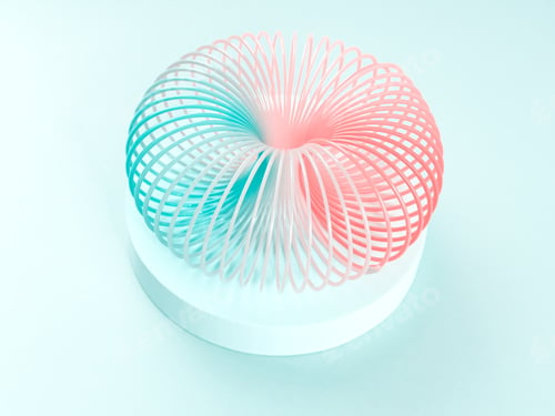 Preview: Colorful pastel color rainbow spiral plastic toy on turquoise background on podium