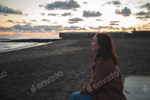 Preview: Woman sitting on the shore and enjoying the sea