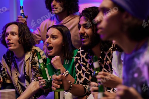 Preview: Group of intercultural tense guys and girl with beer watching broadcast