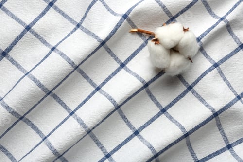 Preview: Fluffy cotton flower on fabric, above view. Space for text