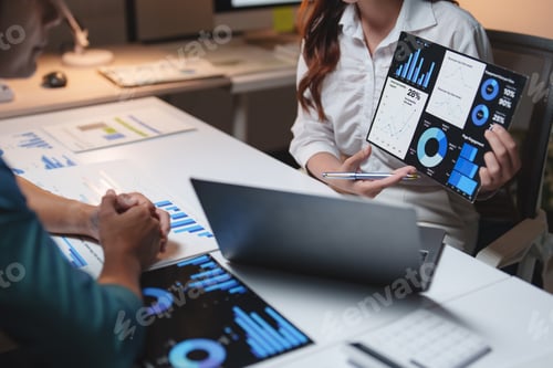 Preview: Business professionals discussing financial data charts in office