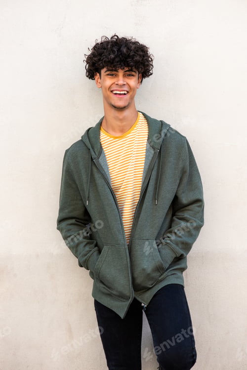 Preview: young North African man smiling by white wall