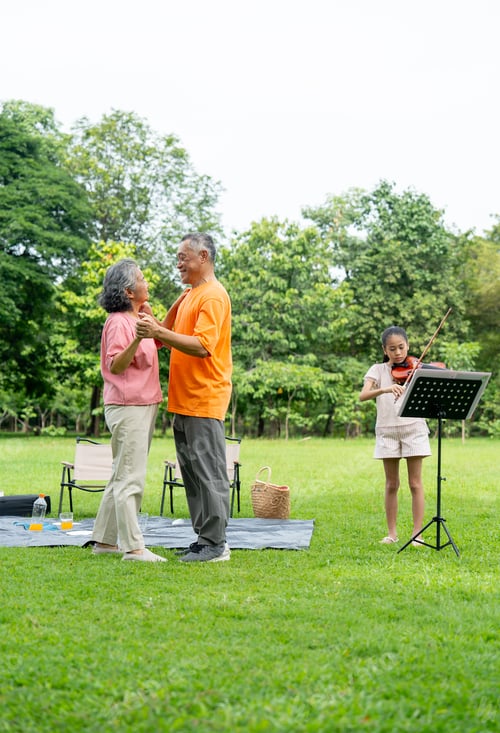 Preview: Vertical image of Asian senior man and woman enjoy to dancing while the girl play violin