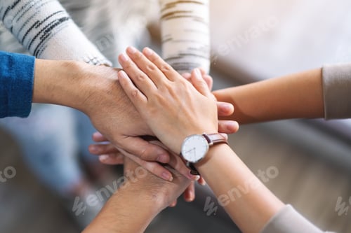 Preview: Top view image of people putting their hands in stack together