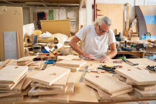 Preview: Carpenter working at workspace producing handmade wooden crafts.