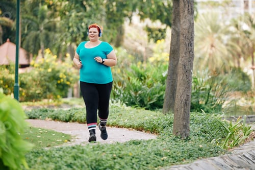 Preview: Plus size woman running in park