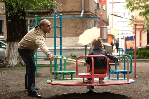 Preview: family having fun on the playground on a swing