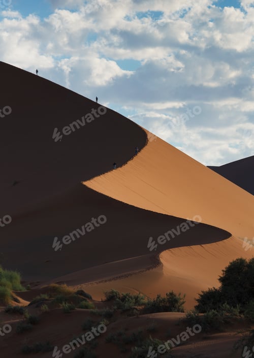 Preview: Two people climbing giant sand dune, Sossusvlei National Park, Namibia