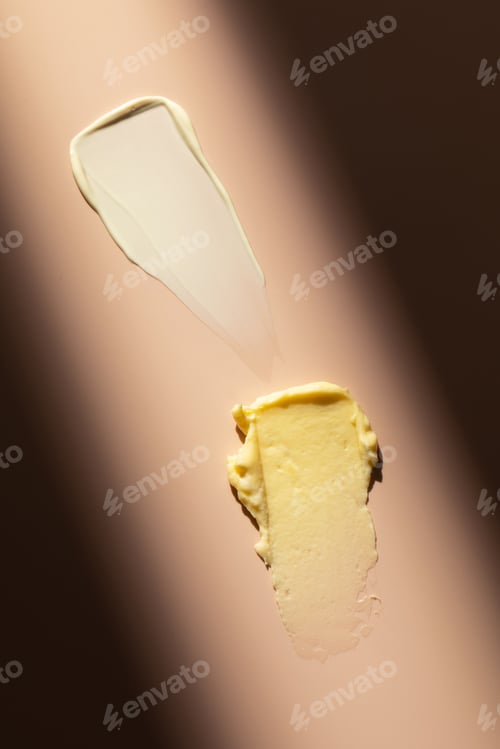 Preview: Swatches. A samples of a cream, cosmetic product on a pink background with a hard shadow.