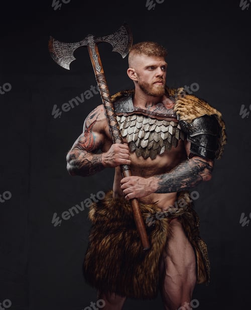 Preview: Brutal tattooed warrior wearing light armour and fur holding two-handed axe in dark studio