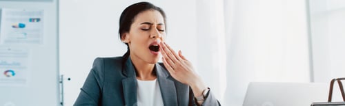 Preview: panoramic shot of tired latin businesswoman yawning with closed eyes in office