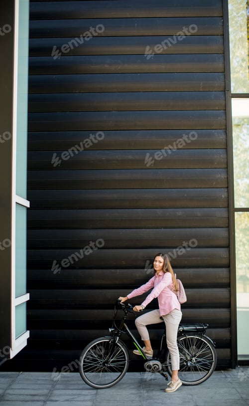 Preview: Young woman with modern city electric e-bike as clean sustainable urban transportation