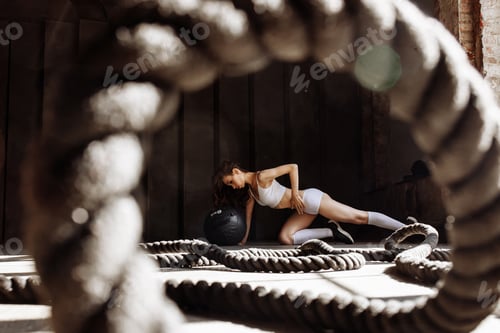 Preview: Beautiful woman in the gym, photo through a loop of sports rope.