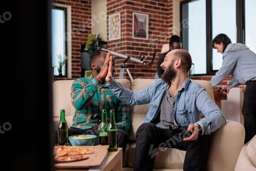 Preview: Diverse team of friends doing highfive gesture after winning video games