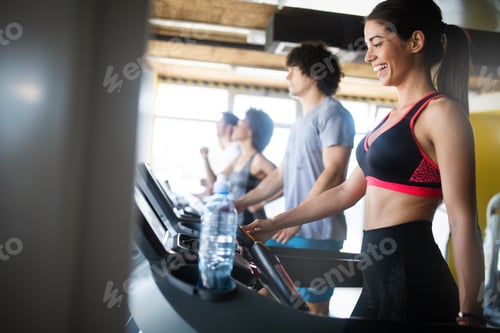 Preview: Beautiful fit people exercising together in gym